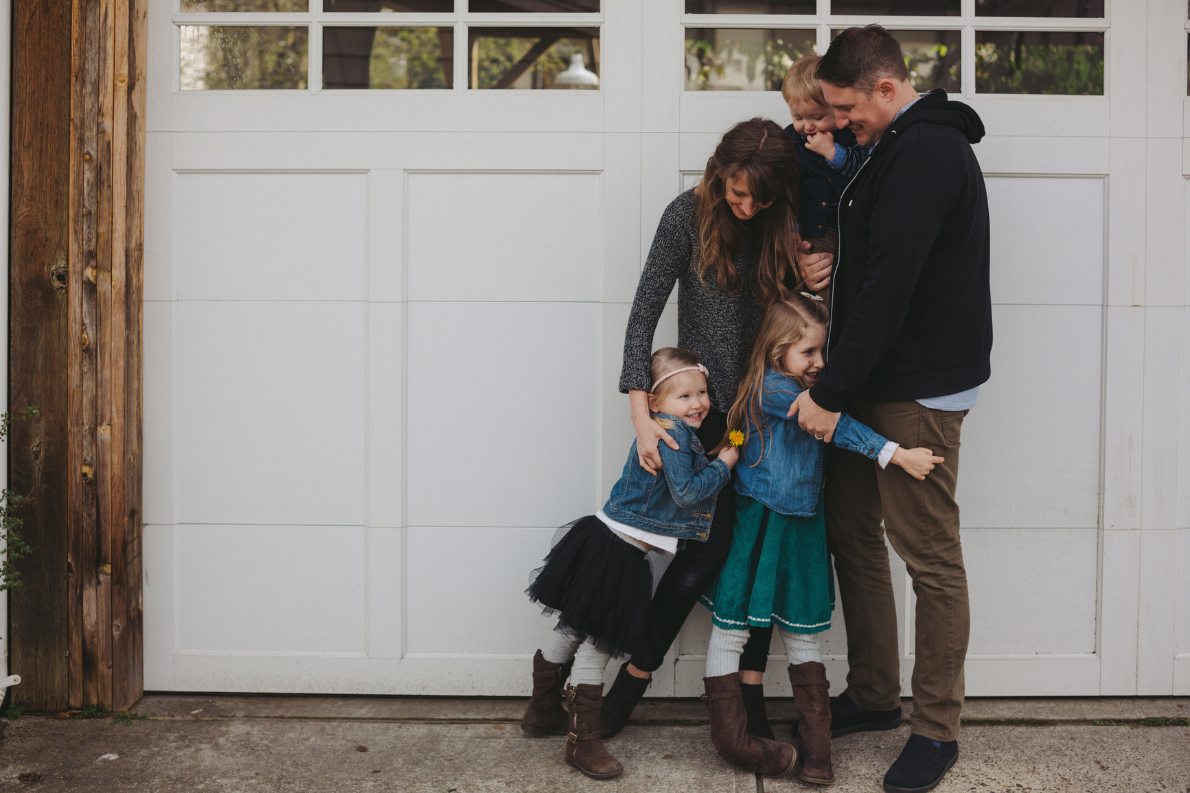 Young family of five enjoying time -hugging together outside nea