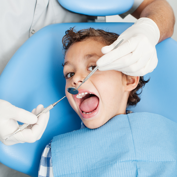 At the dentist's office. Appears a dentist, a patient, a nurse a