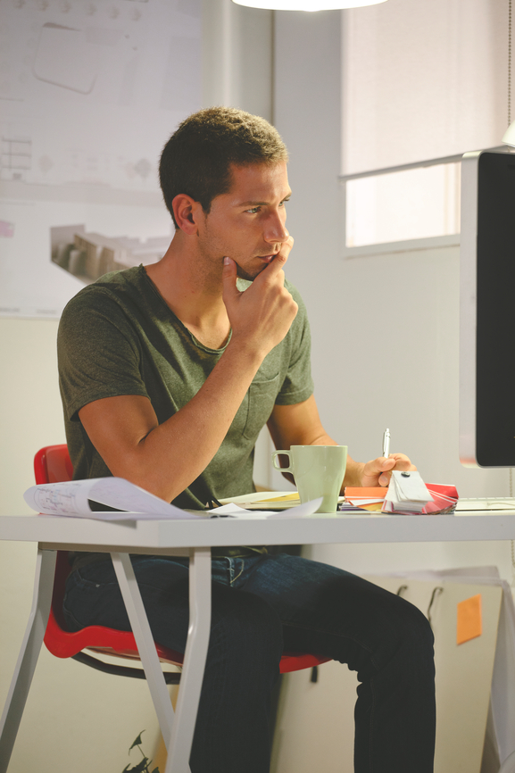Young creative man working with computer in her office.