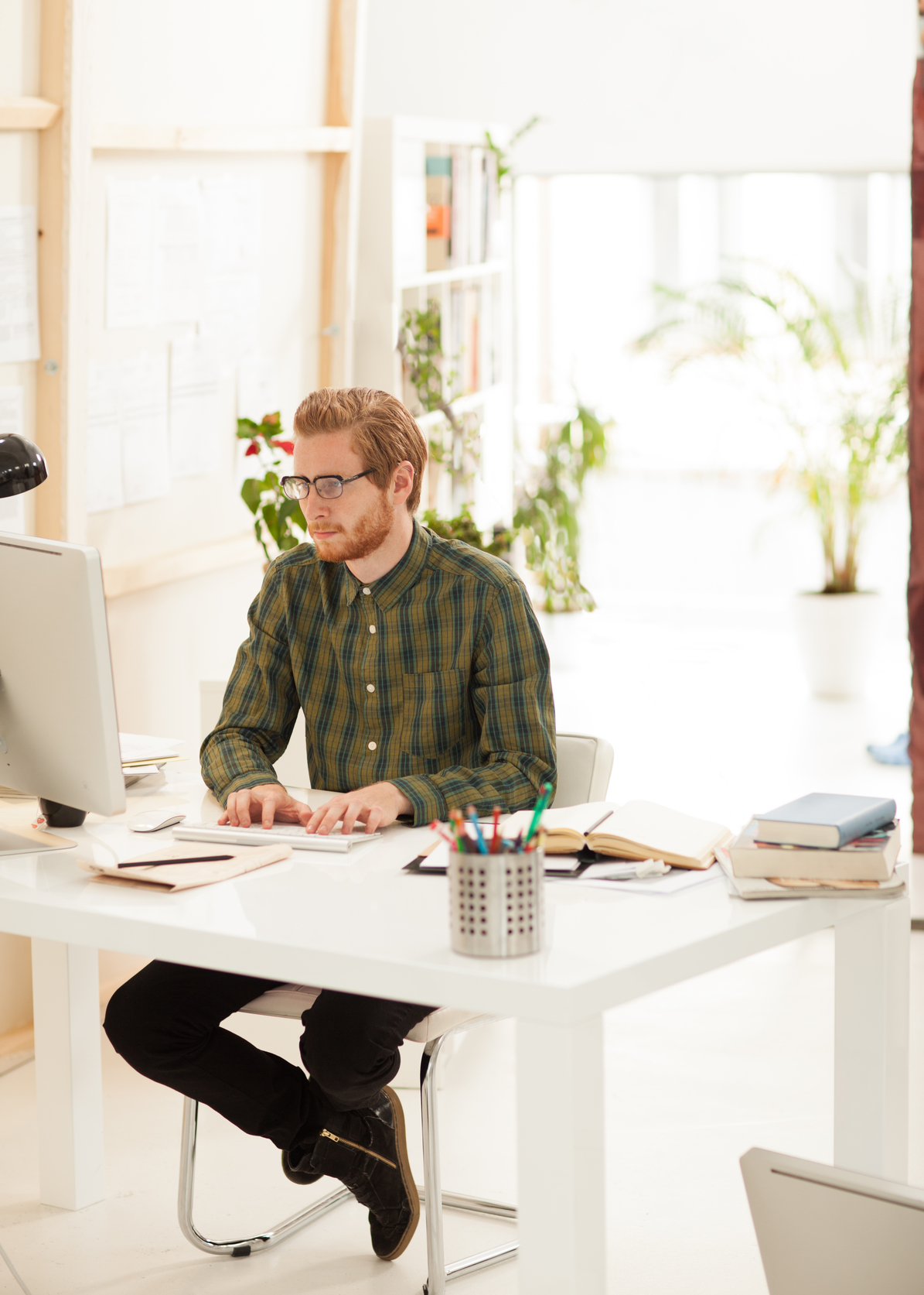 Young businessman working on the computer at his modern spacious office.
