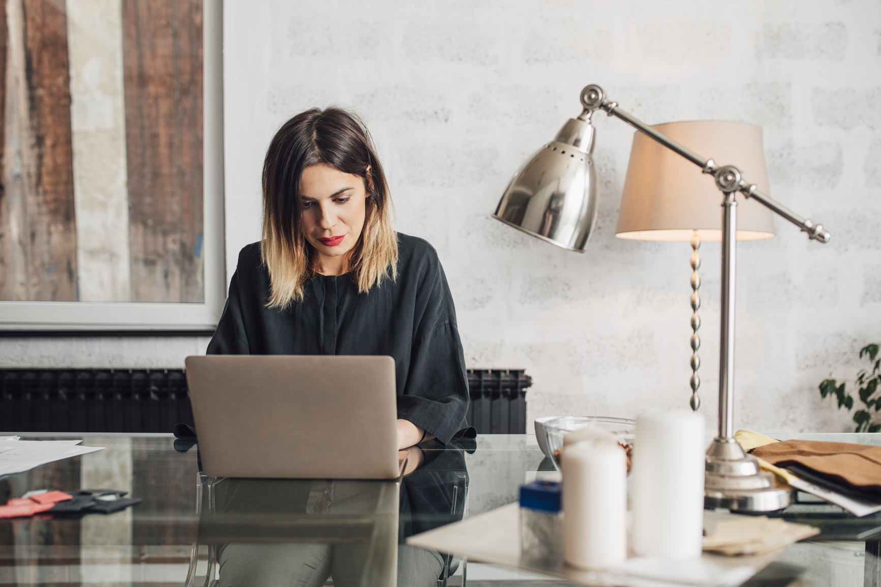 Pretty Caucasian woman sitting at her office deks and working on her laptop.